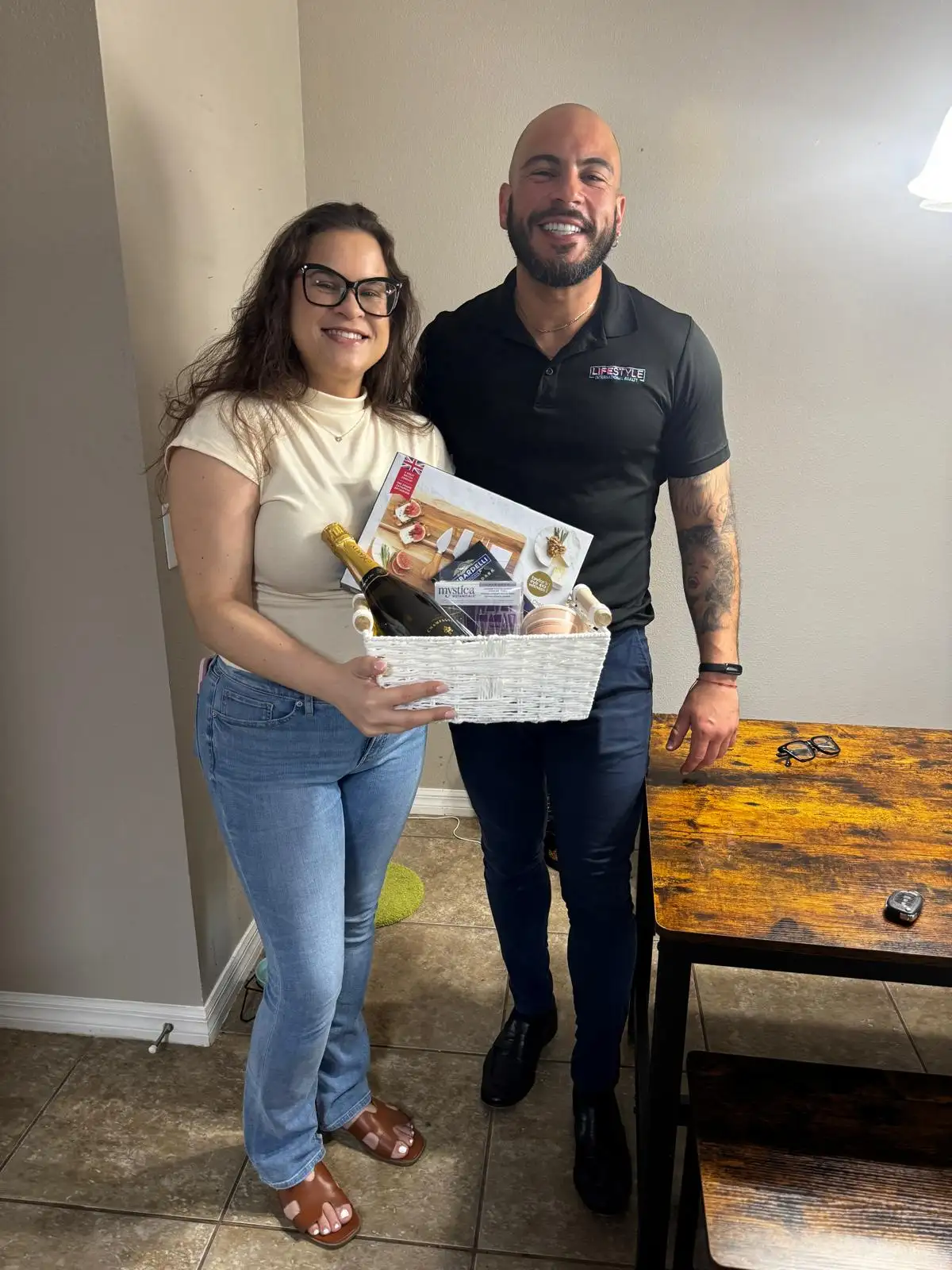 Jose with a happy homebuyer holding a closing gift basket